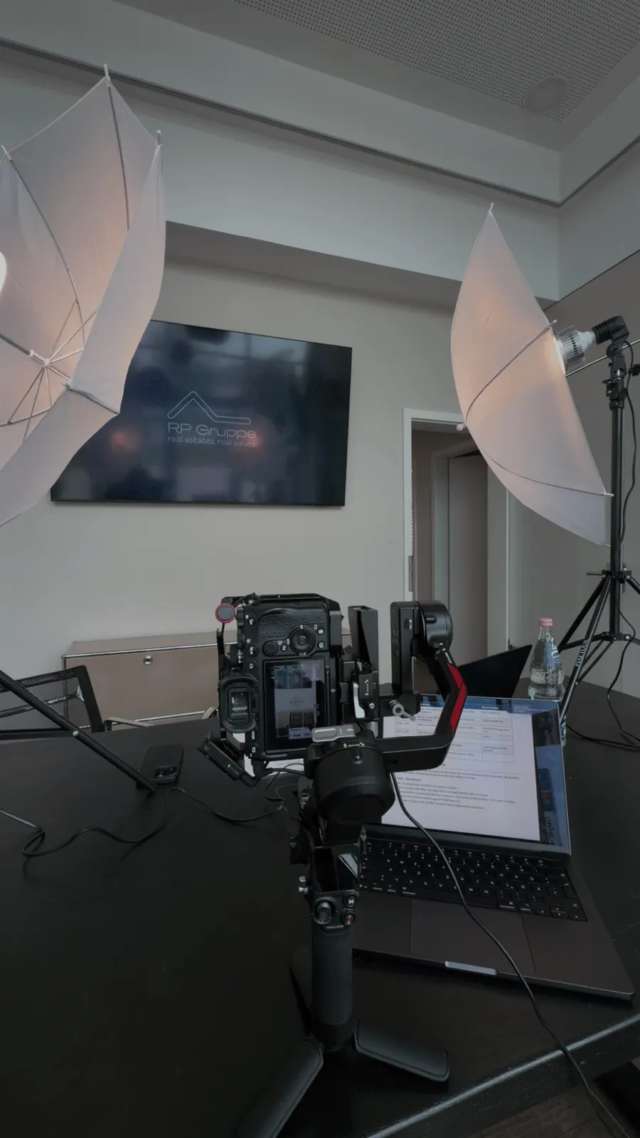 Behind the Scenes: Kamera mit Gimbal und Studiolicht beim Drehtag in einem Besprechungsraum